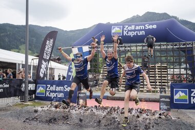 3 Teilnehmer springen über ein Feuer als letztes Hindernis beim Spartan Race | © Zell am See-Kaprun Tourismus